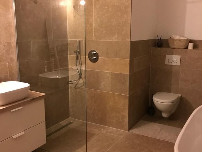 Bathroom with walk-in shower and tiling